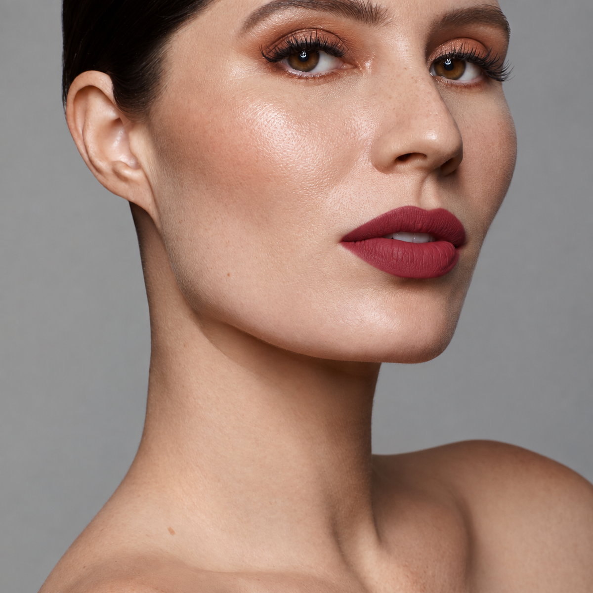 Model wearing LILIPANI Lippy in a Bottle vegan matte liquid lipstick in Desire, a deep berry rose